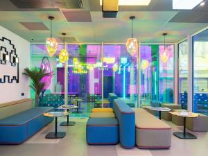 a restaurant with tables and chairs and colorful lighting at ibis Styles Béziers Centre in Béziers