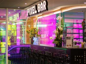 a pink bar with black chairs in front of it at ibis Styles Béziers Centre in Béziers