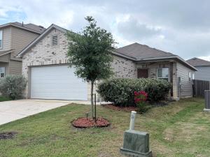a house with a tree in front of a garage at Cozy Retreat in San Antonio