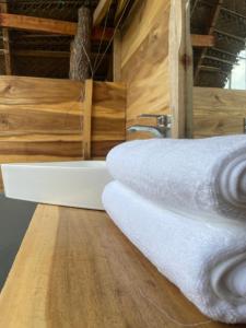 a bathroom with white towels on a wooden counter at Foresta Yala in Tissamaharama