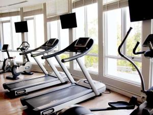 a gym with three treadmills in a room with windows at Novotel Ha Long Bay Hotel in Ha Long