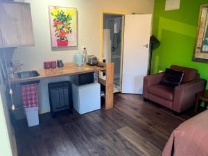 a small kitchen with a counter and a chair in a room at Inner City Oasis in Invercargill