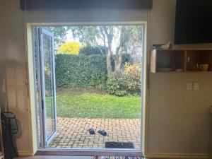 an open door to a patio with a view of a yard at Inner City Oasis in Invercargill