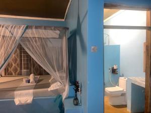 a blue room with a bed and a toilet at Afro Beach Safari in Kilindoni