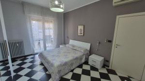 a bedroom with a bed and a checkered floor at Appartamento Saretta in Asti