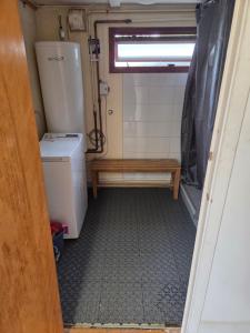 a small bathroom with a toilet and a refrigerator at Ofvansjö Gård , Enkel stuga för övernattning på ett fd militärområde in Sandviken