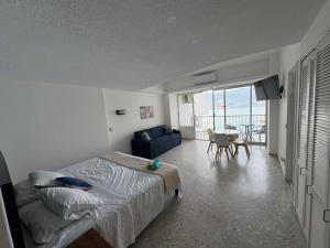 a bedroom with a bed and a couch and a table at Loft con vista al mar, playa, wifi, súper ubicado in Acapulco +15 photos