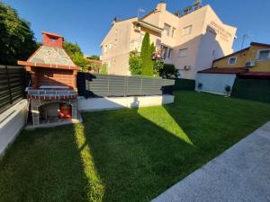 a backyard with a pizza oven on the grass at Silitur Keramoti in Keramoti