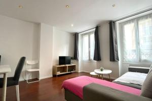 a bedroom with a bed and a tv and a table at 35 min from Paris - Saint Maurice - Chez Nolan in Saint-Maurice