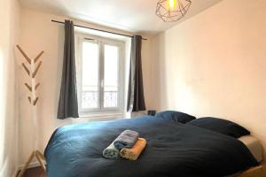 a bedroom with a blue bed with a window at 35 min from Paris - Saint Maurice - Chez Nolan in Saint-Maurice +4 photos