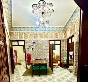a room with a table and a chandelier at Villa ben lahbib II in Khenifra