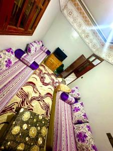 a room with two beds with colorful sheets at Villa ben lahbib II in Khenifra