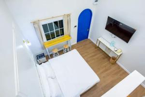 a living room with a white couch and a tv at British Hill Resort สัตหีบ บางเสร่ ช่องเเสมสาร in Ban Tao Than