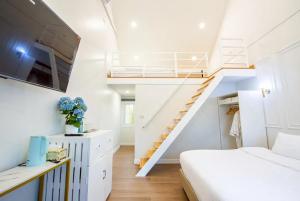 a bedroom with a bed and a staircase at British Hill Resort สัตหีบ บางเสร่ ช่องเเสมสาร in Ban Tao Than