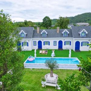 a large white house with a pool in the yard at British Hill Resort สัตหีบ บางเสร่ ช่องเเสมสาร in Ban Tao Than