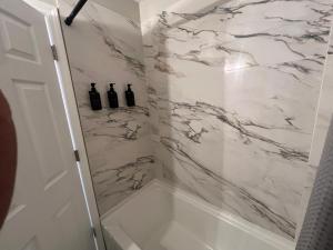 a bathroom with a shower with white marble at Greystone Ranch Pet Friendly in Clarksville +23 photos
