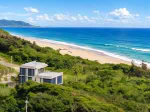 a house on a hill next to a beach at Private Villa The Beach AMAMI in Tatsugo
