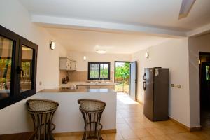 a kitchen with a counter and two bar stools at Résidence Swiss Nosy be in Nosy Be