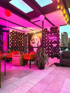 a restaurant with pink lighting and a wall of wine barrels at Hotel Lleras # 1 in Medellín