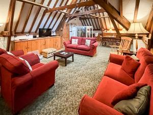 a living room with red couches and a tv at Granary - Uk51016 in Louth