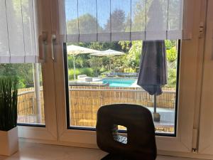 a chair in front of a window with a view of a pool at Memminger Stadtnest Donaustr 4 in Memmingen