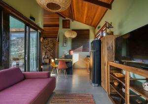a living room with a purple couch and a table at Casa do Teuler - Lapinha da Serra in Santana do Riacho