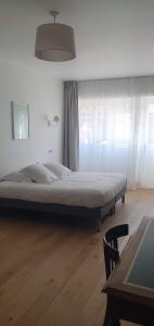 a bedroom with a bed and a wooden floor at Les Cabines in Houlgate