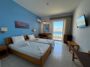 a bedroom with a bed and a view of the ocean at Olympic Hotel in Karpathos