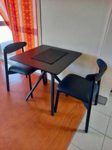 a black table and two chairs and a table and chairs at Kuki Beach Bach in Rarotonga