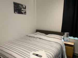 a bedroom with a bed with a remote control on it at Haven House in Hull