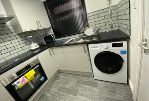 a kitchen with a washing machine and a sink at Haven House in Hull