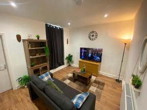 a living room with a couch and a flat screen tv at Haven House in Hull