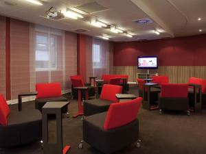 a waiting room with red chairs and a flat screen tv at Novotel Liverpool Centre in Liverpool +83 photos