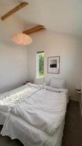 a large white bed in a room with a window at Viking Surf & Stay in Klitmøller
