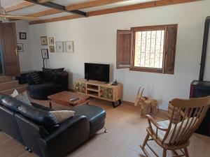 a living room with a leather couch and a tv at casita la bugamvilla in Mojácar