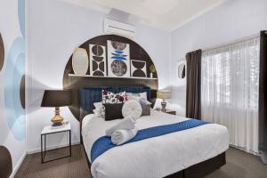 a bedroom with a large bed with towels on it at Eleda House Hunter Valley Escape in Cessnock