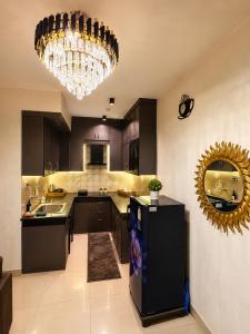 a kitchen with black cabinets and a chandelier at Ballentines Bliss in Babarpur