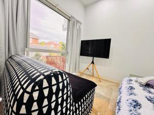a bedroom with a bed and a large window at Relax and Retreat Studio Flat in Glenwood