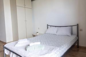 a bedroom with a bed with white sheets and pillows at Elia mini suite 2 in Larisa