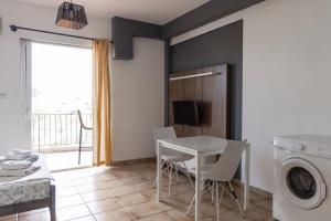 a laundry room with a table and chairs and a washing machine at Elia mini suite 2 in Larisa