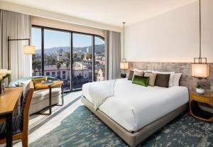 a hotel room with a large bed and a desk at Dream Hollywood, by Hyatt in Los Angeles