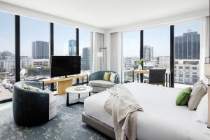 a bedroom with a large white bed and a large window at Dream Hollywood, by Hyatt in Los Angeles