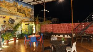 a restaurant with tables and chairs and a mural at Rajputana cafe and restaurant in Dausa