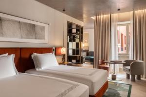 a hotel room with two beds and a living room at Thompson Rome, By Hyatt in Rome +26 photos