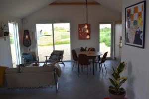 a living room with a couch and a table and chairs at Viking Surf & Stay in Klitmøller