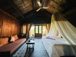 a bedroom with a bed and a couch in a room at Cabalina Grove in Ðảo Cát Bà