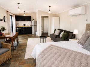 a living room with a large bed and a kitchen at Coastal Studio in Seacliff