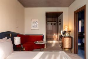 a living room with a red couch and a table at Thompson Rome, By Hyatt in Rome