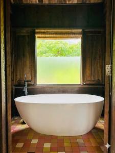 a large white tub in a room with a window at Cabalina Grove in Ðảo Cát Bà +88 photos