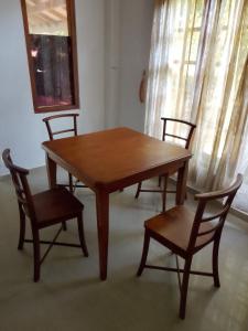 a wooden table and two chairs and a table and a table at GD Guest in Bentota